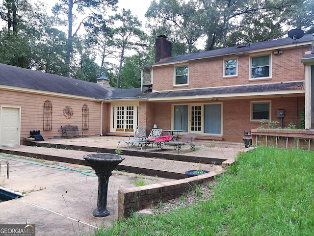 5001 Old Dawson Rd, Albany, GA 31721 - back of house with brick siding, a patio, and a chimney