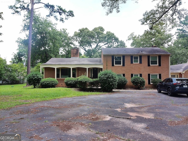 5001 Old Dawson Rd, Albany, GA 31721 - view of front of home featuring a chimney, a front yard, and brick siding