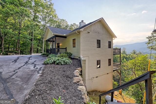 63 Maple Ridge Trl, Clayton, GA 30525 - view of property exterior featuring a chimney, driveway, and a shingled roof