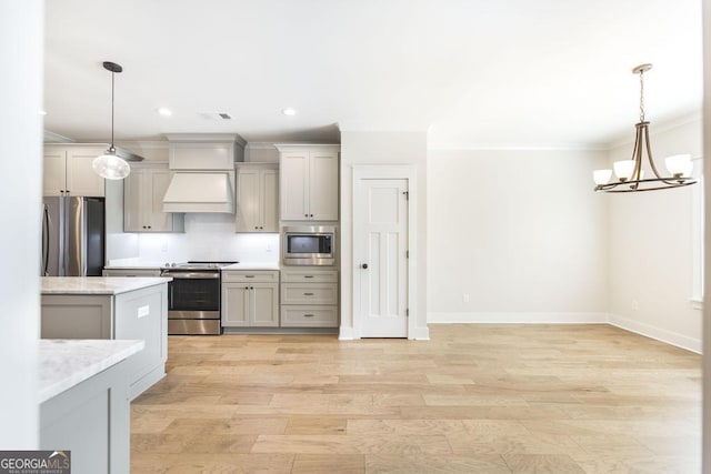 115 Gracetree Way, Kathleen, GA 31047 - kitchen featuring appliances with stainless steel finishes, ornamental molding, premium range hood, a chandelier, and light wood-style flooring