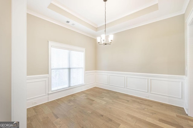 115 Gracetree Way, Kathleen, GA 31047 - empty room featuring ornamental molding, a chandelier, a tray ceiling, a wainscoted wall, and light wood-style flooring