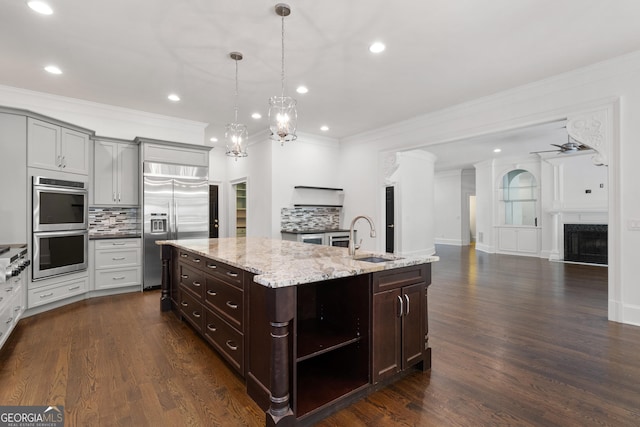 1650 Harvest Ln, Alpharetta, GA 30004 - kitchen with appliances with stainless steel finishes, backsplash, crown molding, a kitchen island with sink, and recessed lighting