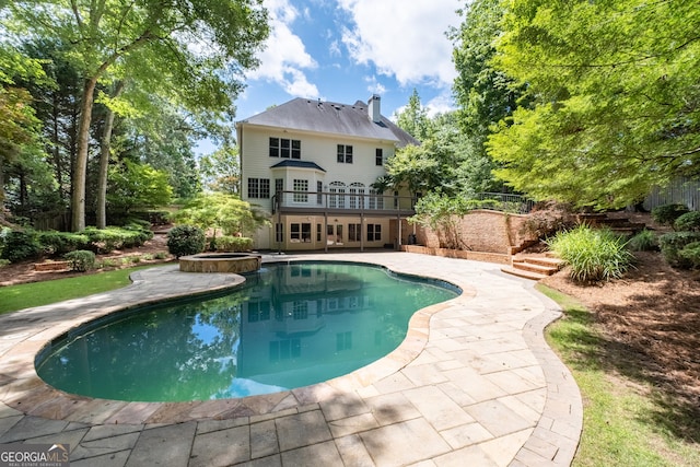 1650 Harvest Ln, Alpharetta, GA 30004 - rear view of house with a patio area, a pool with connected hot tub, a chimney, and a metal roof