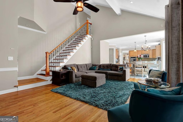 1875 Edgemont Ct, Cumming, GA 30041 - living room featuring high vaulted ceiling, stairs, a ceiling fan, light wood finished floors, and a chandelier