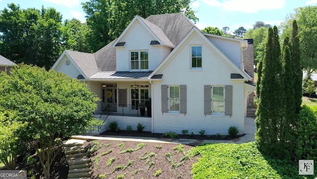 1635 Broadwell Oaks Dr, Alpharetta, GA 30004 - view of front facade with a standing seam roof, brick siding, a porch, roof with shingles, and a metal roof
