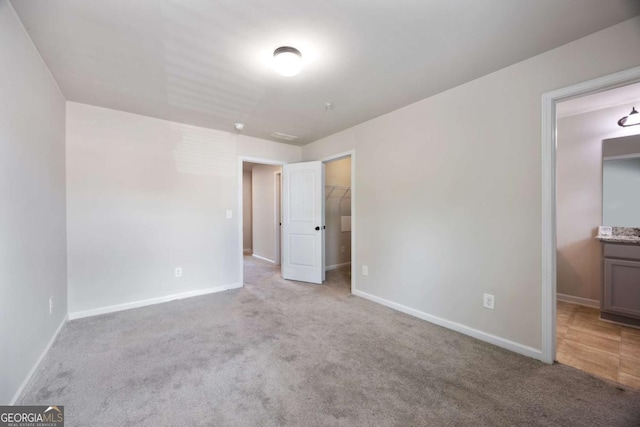 1005 Bayrose Cir Unit 5A, Atlanta, GA 30344 - unfurnished bedroom with carpet floors, a walk in closet, and ensuite bath