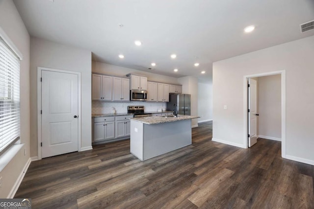 1005 Bayrose Cir Unit 5A, Atlanta, GA 30344 - kitchen with stainless steel appliances, a kitchen island with sink, dark wood-style flooring, tasteful backsplash, and recessed lighting