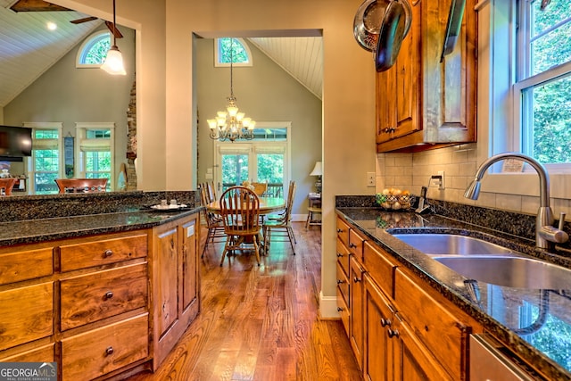249 Dalton Dr, Dillard, GA 30537 - kitchen with high vaulted ceiling, plenty of natural light, brown cabinets, wood finished floors, and dark stone countertops
