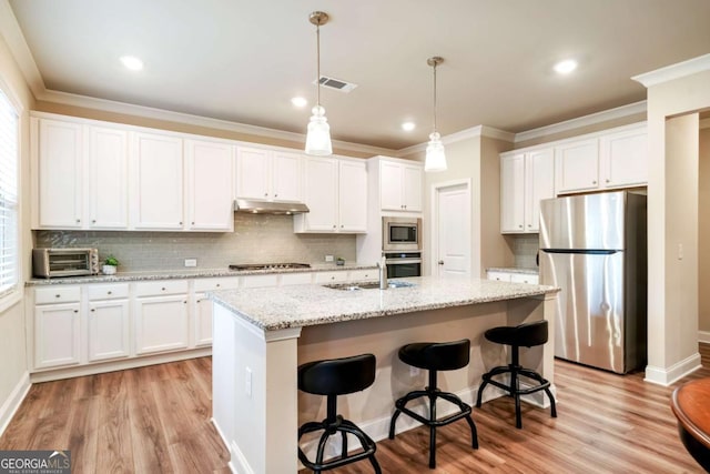 4636 SW Silver Oak Dr SW, Gainesville, GA 30504 - kitchen featuring stainless steel appliances, under cabinet range hood, ornamental molding, light wood-style floors, and white cabinets