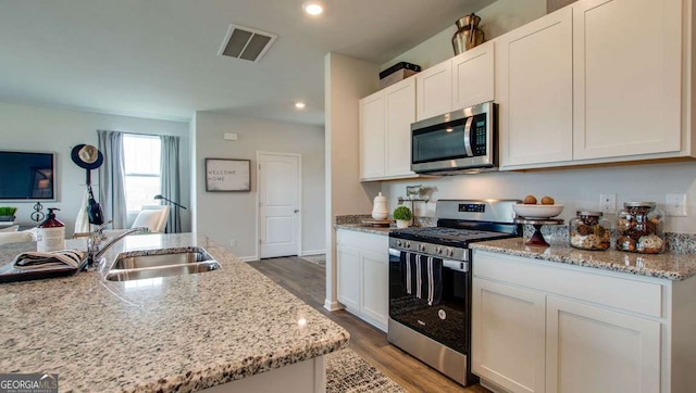 11899 Aukerman Way, Hampton, GA 30228 - kitchen with stainless steel appliances, light wood-type flooring, white cabinetry, light stone counters, and recessed lighting