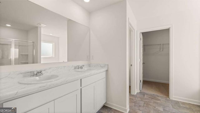 11899 Aukerman Way, Hampton, GA 30228 - bathroom featuring a shower stall, stone finish flooring, a spacious closet, double vanity, and recessed lighting