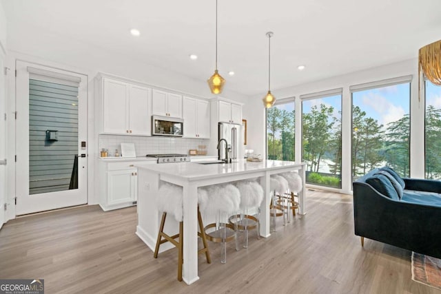 103 Marina Parc Dr, Waleska, GA 30183 - kitchen with appliances with stainless steel finishes, light countertops, light wood-type flooring, backsplash, and white cabinetry