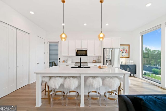 103 Marina Parc Dr, Waleska, GA 30183 - kitchen featuring stainless steel appliances, tasteful backsplash, light countertops, a kitchen island with sink, and recessed lighting
