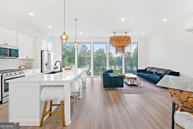 103 Marina Parc Dr, Waleska, GA 30183 - kitchen featuring appliances with stainless steel finishes, open floor plan, light countertops, tasteful backsplash, and light wood-type flooring
