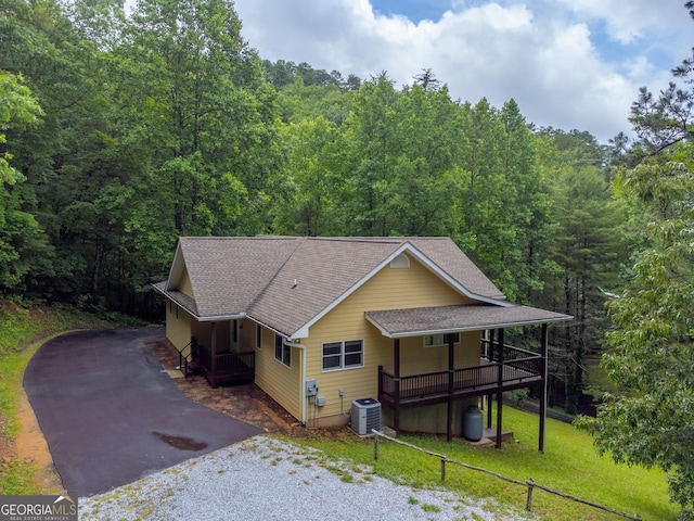 55 Cool Spring Ln, Clayton, GA 30525 - view of front of home featuring a shingled roof, a view of trees, driveway, a front yard, and covered porch