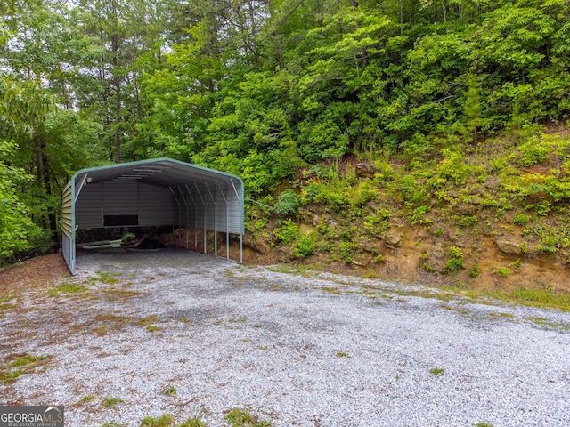 55 Cool Spring Ln, Clayton, GA 30525 - view of parking featuring a detached carport, a wooded view, and driveway
