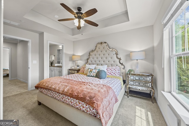1004 Bayrose Cir, East Point, GA 30344 - carpeted bedroom featuring multiple windows, a tray ceiling, ensuite bathroom, and ceiling fan