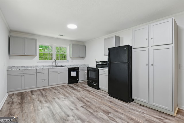 1469 Tabernacle Church Rd, Lincolnton, GA 30817 - kitchen featuring black appliances, gray cabinetry, light countertops, light wood-type flooring, and ornamental molding