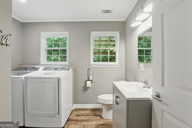 1469 Tabernacle Church Rd, Lincolnton, GA 30817 - bathroom with washing machine and clothes dryer, vanity, ornamental molding, healthy amount of natural light, and wood finished floors