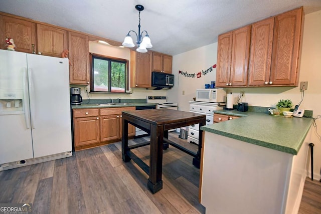 780 Watson Gap Rd, Mineral Bluff, GA 30559 - kitchen featuring white appliances, a chandelier, dark wood-style flooring, a peninsula, and pendant lighting