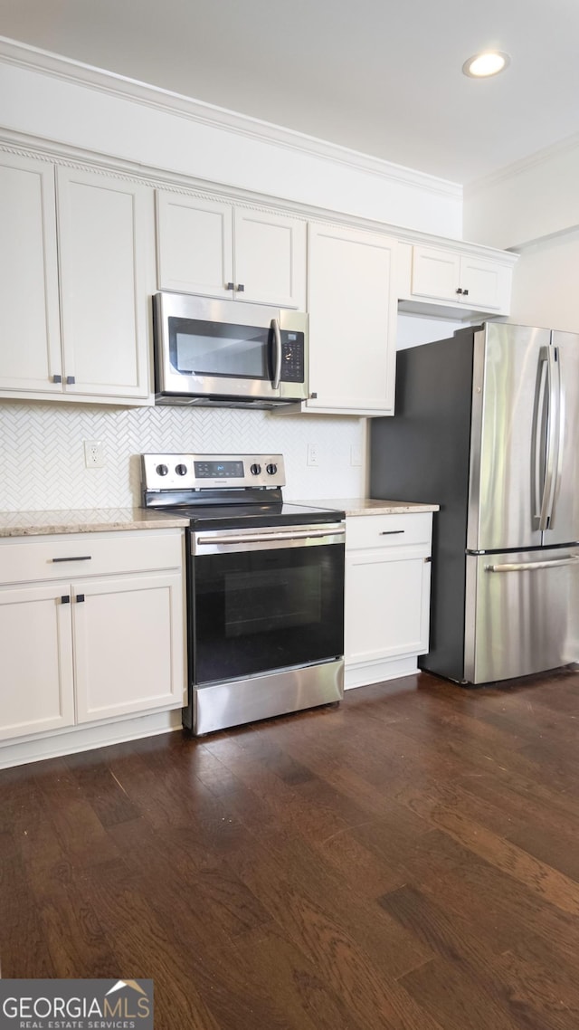 996 Palmetto Ave SW, Atlanta, GA 30314 - kitchen featuring stainless steel appliances, ornamental molding, decorative backsplash, dark wood-type flooring, and white cabinets