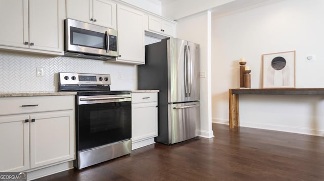 996 Palmetto Ave SW, Atlanta, GA 30314 - kitchen featuring stainless steel appliances, decorative backsplash, dark wood-style flooring, white cabinets, and ornamental molding