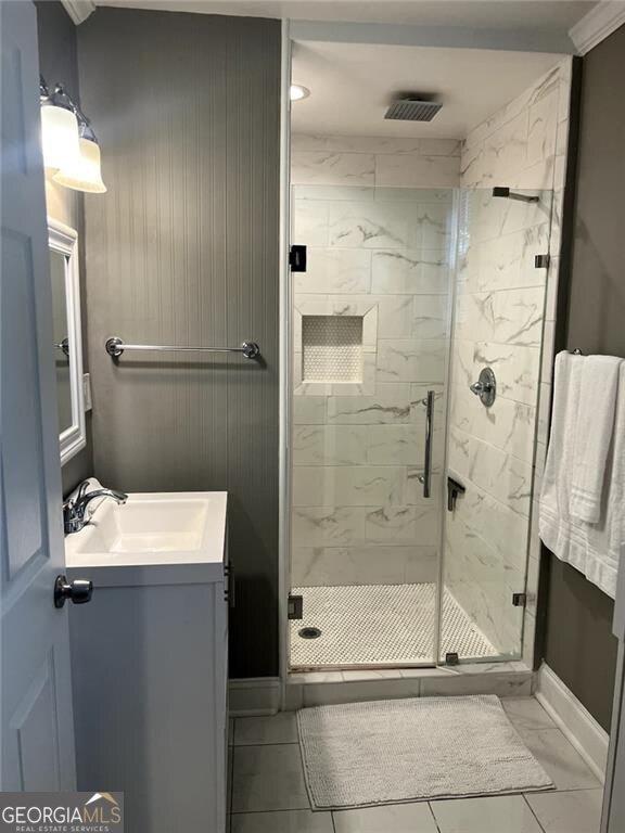 996 Palmetto Ave SW, Atlanta, GA 30314 - bathroom featuring vanity, a marble finish shower, and marble look tiles