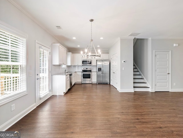 9701 Davis St, Braselton, GA 30517 - kitchen with appliances with stainless steel finishes, a chandelier, crown molding, tasteful backsplash, and white cabinets