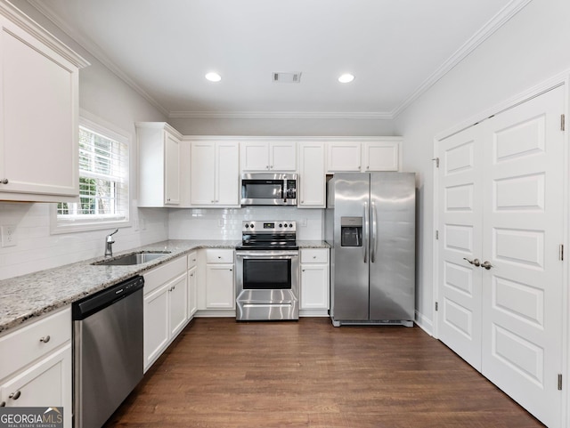9701 Davis St, Braselton, GA 30517 - kitchen featuring stainless steel appliances, white cabinetry, crown molding, light stone counters, and dark wood finished floors