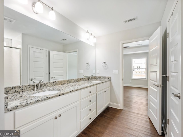 9701 Davis St, Braselton, GA 30517 - full bathroom with wood finished floors, double vanity, and a shower stall