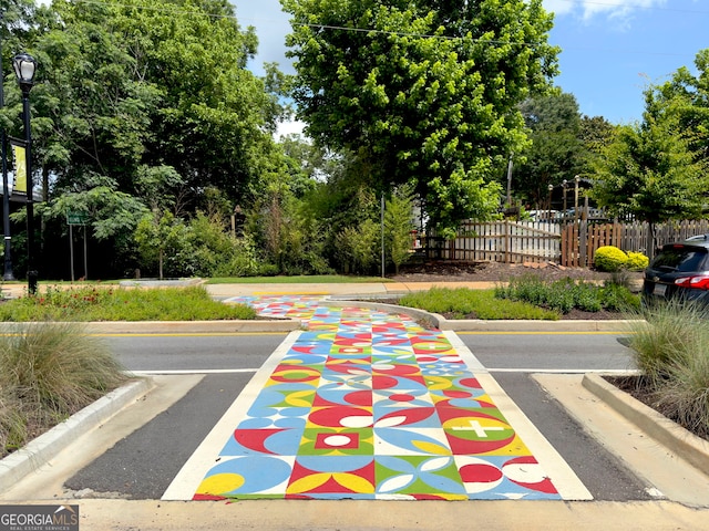 9701 Davis St, Braselton, GA 30517 - view of asphalt road featuring curbs, street lighting, and view of wooded area
