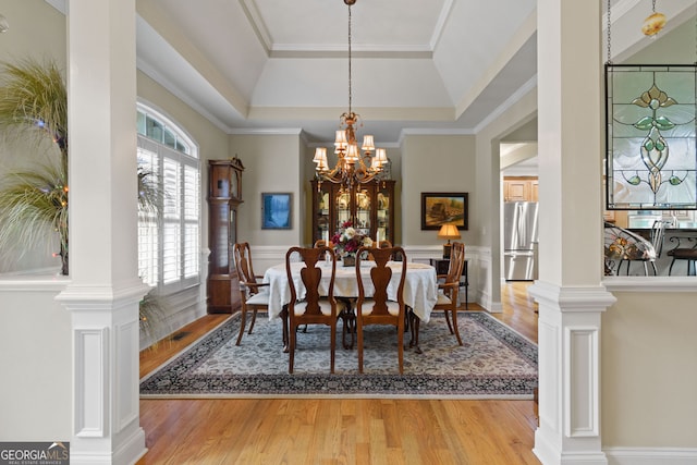 281 Hightower Lake Trl, Ball Ground, GA 30107 - dining space featuring a raised ceiling, light wood-style floors, a chandelier, ornamental molding, and a wainscoted wall