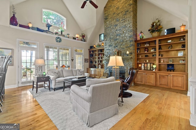 281 Hightower Lake Trl, Ball Ground, GA 30107 - living room with light wood-type flooring, high vaulted ceiling, ceiling fan, and a stone fireplace