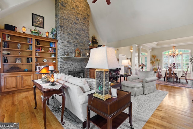 281 Hightower Lake Trl, Ball Ground, GA 30107 - living area featuring light wood-style flooring, ornate columns, a ceiling fan, a chandelier, and a stone fireplace