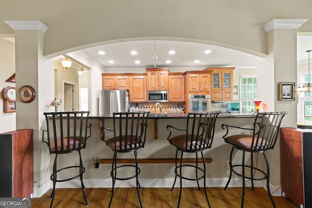 281 Hightower Lake Trl, Ball Ground, GA 30107 - kitchen featuring appliances with stainless steel finishes, a kitchen breakfast bar, arched walkways, ornamental molding, and recessed lighting