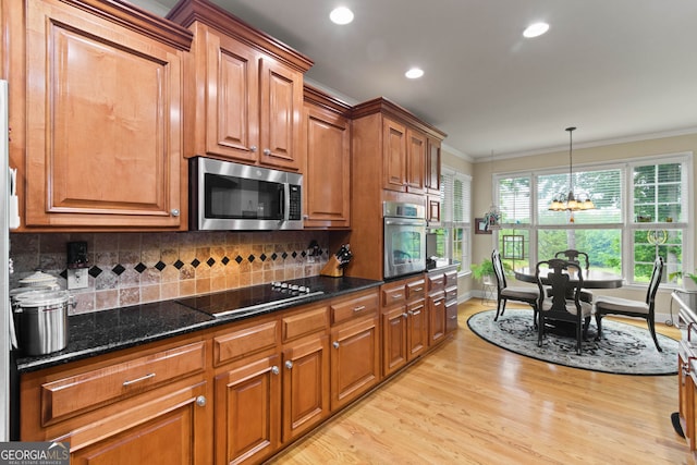 281 Hightower Lake Trl, Ball Ground, GA 30107 - kitchen with stainless steel appliances, a chandelier, ornamental molding, light wood-style floors, and brown cabinetry