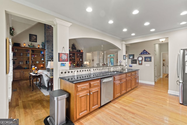 281 Hightower Lake Trl, Ball Ground, GA 30107 - kitchen featuring appliances with stainless steel finishes, decorative columns, light wood-style flooring, crown molding, and brown cabinets
