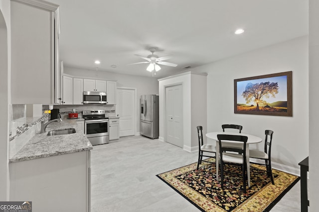 281 Hightower Lake Trl, Ball Ground, GA 30107 - kitchen with appliances with stainless steel finishes, ceiling fan, light stone counters, recessed lighting, and arched walkways