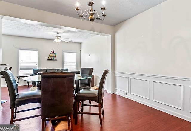 2555 Flat Shoals Rd Apt 2006, South Fulton, GA 30349 - dining space with dark wood-style floors, a ceiling fan, a chandelier, a textured ceiling, and a wainscoted wall