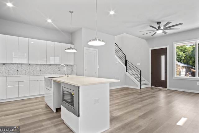 569 Middle St SW, Atlanta, GA 30310 - kitchen featuring stainless steel microwave, modern cabinets, white cabinetry, light wood-style floors, and recessed lighting