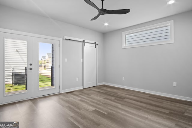 569 Middle St SW, Atlanta, GA 30310 - unfurnished bedroom with access to exterior, a barn door, french doors, dark wood-style floors, and recessed lighting