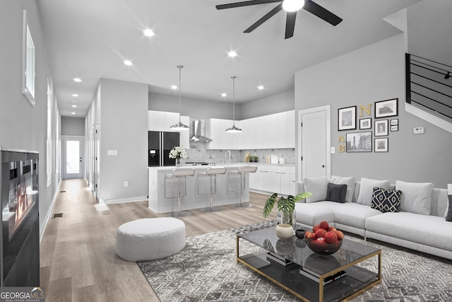 569 Middle St SW, Atlanta, GA 30310 - living room with ceiling fan, light wood-style floors, recessed lighting, and a towering ceiling