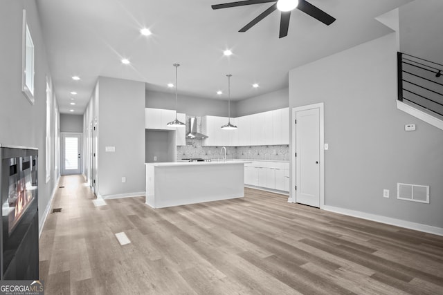 569 Middle St SW, Atlanta, GA 30310 - unfurnished living room with a ceiling fan, light wood-type flooring, a multi sided fireplace, recessed lighting, and a towering ceiling