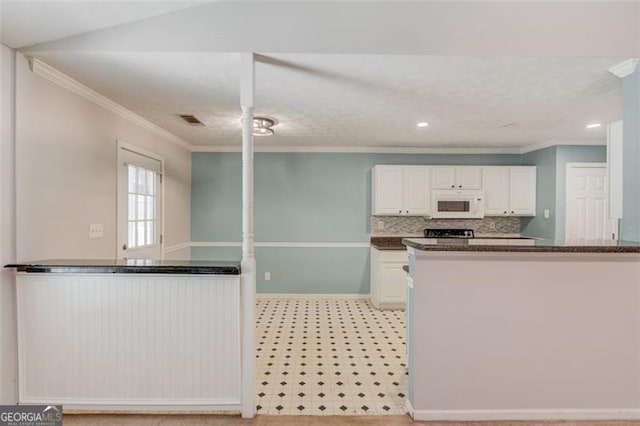 738 Baskins, Winder, GA 30680 - kitchen featuring white microwave, white cabinets, crown molding, tasteful backsplash, and a peninsula