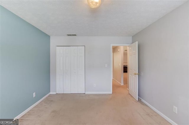 738 Baskins, Winder, GA 30680 - unfurnished bedroom with light colored carpet, a closet, and a textured ceiling