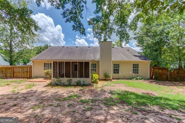 738 Baskins, Winder, GA 30680 - rear view of house featuring a sunroom, a chimney, and a fenced backyard