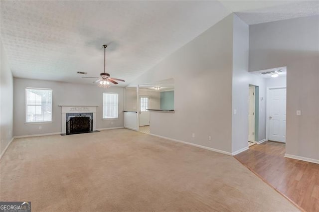 738 Baskins, Winder, GA 30680 - unfurnished living room featuring a ceiling fan, a premium fireplace, high vaulted ceiling, and light colored carpet