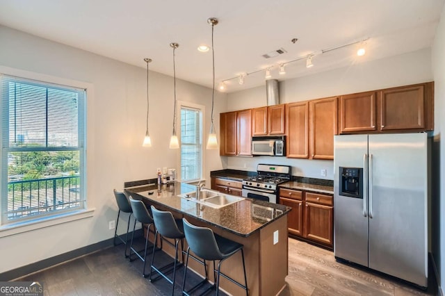 1195 Milton Ter Unit 5204, Atlanta, GA 30315 - kitchen with stainless steel appliances, brown cabinetry, wood finished floors, and a breakfast bar area