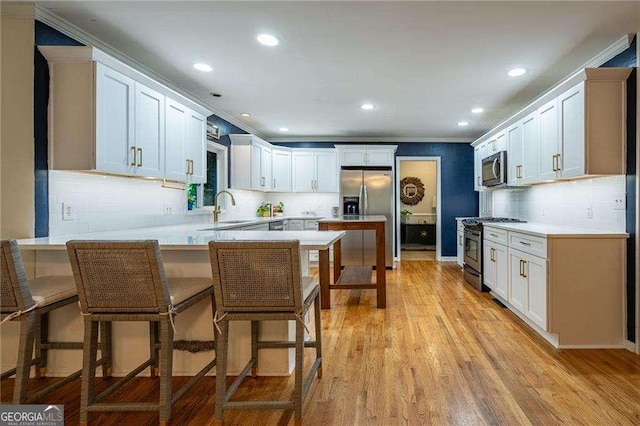 3300 Wiltshire Dr, Avondale Estates, GA 30002 - kitchen featuring stainless steel appliances, a peninsula, light countertops, recessed lighting, and a breakfast bar area