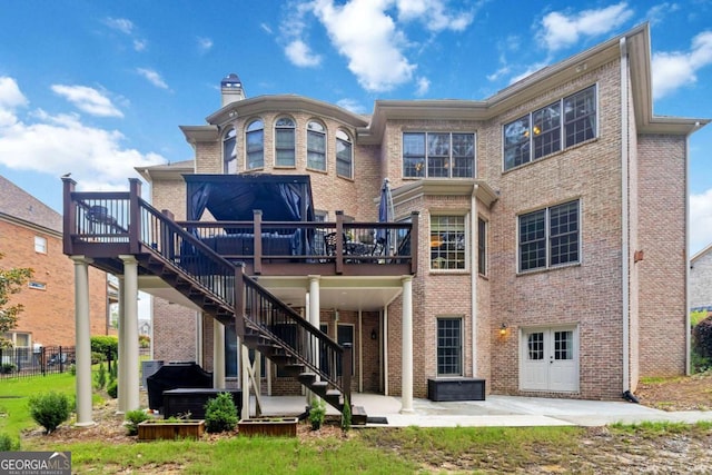 2230 Cambridge Hill Ct, Dacula, GA 30019 - rear view of property featuring a patio, a wooden deck, brick siding, stairway, and a hot tub